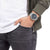 Pulsera de hombre en la muñeca con esfera azul y correa de metal plateado