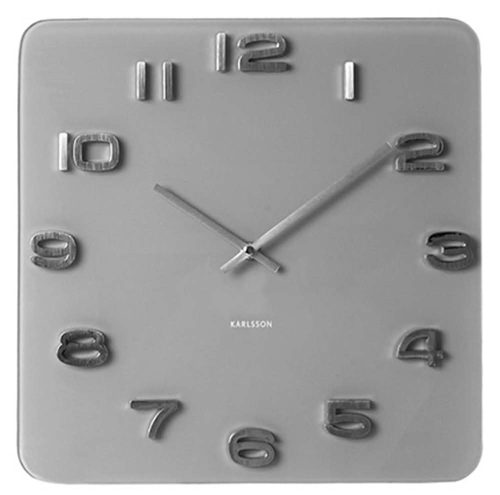 Reloj de pared Karlsson con esfera cuadrada gris, números y manecillas plateadas.