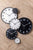 Juego de varios modelos de relojes de pared en negro y claro sobre suelo de madera