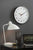 Reloj de pared en la pared con esfera blanca y manecillas de oro rosa