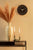 Reloj de pared en la pared con esfera negra y marco de madera clara