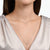 Collar de plata en el cuello con pequeños colgantes de corazón y una piedra de corazón mediana
