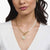 Collar con cadena dorada, perlas y colgante redondo al cuello