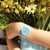 Reloj de mujer con pulsera de plástico azul y esfera analógica redonda en la muñeca