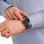 Reloj de hombre en la muñeca con correa marrón y esfera azul oscuro