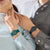 "Reloj de mujer con pulsera de plástico verde en la muñeca, esfera redonda con índices"