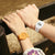 "Reloj de mujer con pulsera naranja y esfera redonda en la muñeca"