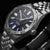Pulsera de hombre vista lateral: caja redonda de acero inoxidable, esfera azul oscuro, brazalete de metal