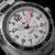 Reloj de hombre, vista de cerca: esfera gris con manecillas y números de hora rojos