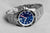 Reloj de buceo con esfera azul, segundero rojo y correa de acero inoxidable