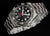 Reloj de hombre con esfera negra, índices luminosos, segundero rojo y brazalete de acero