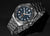 Pulsera para hombre con esfera oscura, detalles en azul y brazalete de acero inoxidable