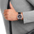Reloj Mondaine Stop2Go en la muñeca con correa de cuero negra y esfera negra