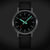 Reloj Mondaine Stop2Go con esfera negra y detalles verde/naranja, correa de cuero negra