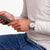 Reloj Mondaine para hombre en la muñeca, vista lateral de la pulsera plateada de acero inoxidable