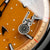 Detalle de la esfera con motivo redondo e índices, esfera naranja, manecillas del reloj
