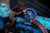 Reloj de hombre con esfera azul y correa de cuero marrón sobre cadena metálica.