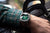 Pulsera de hombre en la muñeca con esfera verde y correa de cuero marrón