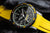 Reloj de hombre con esfera negra, bisel con detalles amarillos y correa amarillo-negra