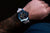 Pulsera de hombre en la muñeca: esfera azul, correa de silicona blanca, bisel azul