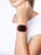 Smartwatch con correa roja en la muñeca, pantalla cuadrada con números