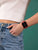 Smartwatch con correa roja en la muñeca, pantalla cuadrada negra
