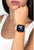Smartwatch en la muñeca con pantalla negra y correa de silicona blanca