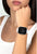 Smartwatch en la muñeca: pantalla negra, correa blanca con marco de pedrería