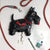 Reloj de pared como figura de perro Scottie negro con collar rojo, esfera y colgador