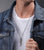 "Collar con colgante de ala en cadena de eslabones, llevado sobre camisa blanca"