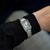 Reloj de mujer en la muñeca con pulsera de acero inoxidable plateado y esfera rectangular