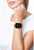 Smartwatch en la muñeca con pantalla negra y correa de malla metálica beige