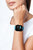 Smartwatch en la muñeca con correa de silicona turquesa, pantalla con hora 10:09.