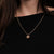 Collar dorado con cadena fina y pequeño colgante de sol al cuello