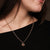 "Collar en top negro: cadena fina con colgante de sol de madera oscura"