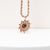 Collar con cadena retorcida de oro rosa y colgante de sol de madera oscura