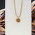 Collar con cadena dorada y colgante de sol con cabujón marrón