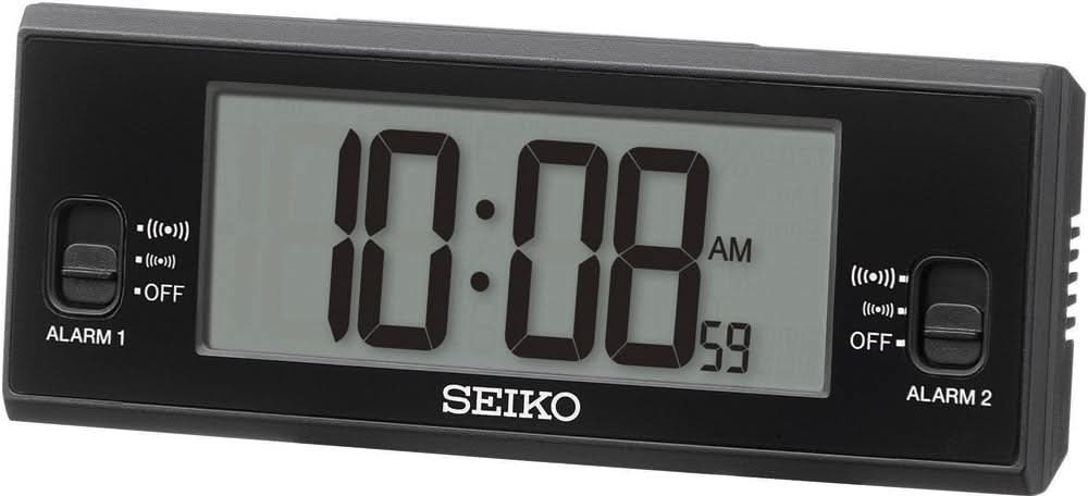 Despertador digital con carcasa negra, pantalla iluminada 10:18 AM y logo SEIKO