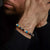 Pulsera con cuentas de piedras preciosas en azul, crema y negro en la muñeca