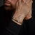Pulsera de piedra con cuentas azules, grises y beige y cierre de acero inoxidable gris en la muñeca