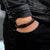 Pulsera de cuero en la muñeca, trenzada marrón oscuro, con cierre rectangular negro