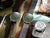 Set de relojes unisex: dos con esfera verde, correas de cuero marrón y metal.