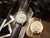 "Reloj unisex con esfera beige y correa de cuero marrón, corona visible"