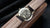 Reloj unisex con tapa trasera grabada y correa de cuero marrón, corona lateral