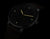 Reloj de hombre con esfera negra, marcadores luminosos y manecillas de colores