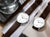 Relojes de mujer uno al lado del otro: correa de cuero marrón, esfera blanca y manecilla central azul
