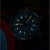 Reloj de hombre con esfera azul y marcadores amarillos luminosos por la noche