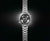 Reloj de pulsera de acero inoxidable con esfera negra, brazalete de acero plateado y pulsadores de cronógrafo.