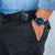 Reloj de hombre en la muñeca con correa de cuero negra y esfera azul