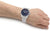 Reloj de hombre en la muñeca: esfera azul, ventana de fecha, brazalete de metal con eslabones